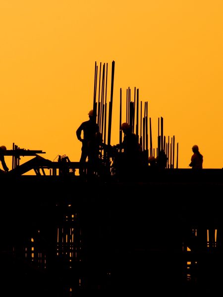 Construction workers at sunset.